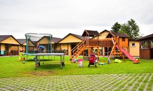 einen Park mit Spielplatz mit Rutsche und Schaukeln in der Unterkunft DOMKI NA TURYSTYCZNEJ in Dąbki