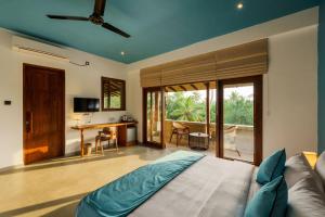 a bedroom with a bed and a living room at Kiss Blossom in Mirissa