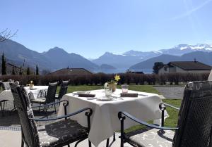 a table and chairs with mountains in the background at Hotel Friedheim in Weggis
