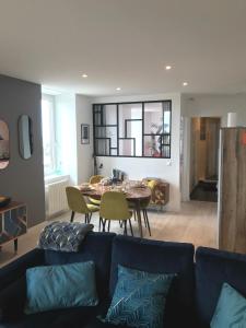 - un salon avec un canapé bleu et une table dans l'établissement Joli appartement très bien situé - Perros-Guirec, à Perros-Guirec