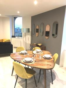 - une salle à manger avec une table, des chaises et des miroirs dans l'établissement Joli appartement très bien situé - Perros-Guirec, à Perros-Guirec