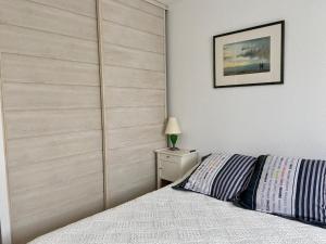a bedroom with a bed with a wooden headboard at Perseides in Argelès-sur-Mer