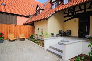 un cortile con sedie e una casa con recinzione di Gasthof Pension Zum goldenen Hirschen a Burgbernheim