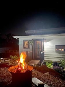 Woodmans Cottage 24, Gold Coast Hinterland في Wongawallan: حفرة نار أمام منزل في الليل