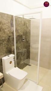 een badkamer met een wit toilet en een douche bij Airport Faith Hotel in Katunayaka