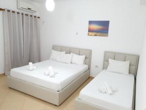 two beds in a small room with white walls at Soare in Ksamil