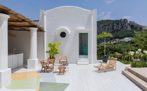 a white house with chairs and a table at Villa Eletta, Capri in Capri