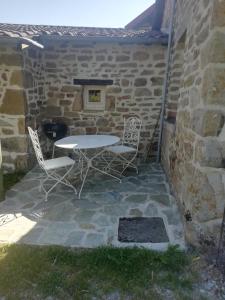 una mesa y sillas sentadas en un patio de piedra en Gîte de caractère en Thauron
