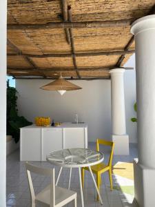 cocina y comedor con mesa de cristal y sillas en Capri Suite Marina Grande, en Capri