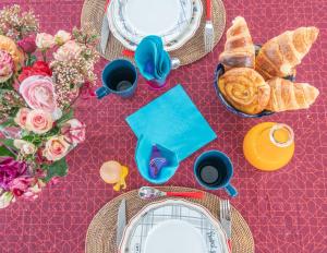 una mesa con platos de comida, pan y flores en Atelier de peinture au Moulin de Gâteau - Atelier sur l'eau, en La Vallée