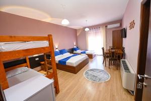 a bedroom with two bunk beds and a dining room at Hotel Epoka in Shkodër