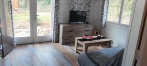 a bedroom with a bed and a tv and a table at Le Chalet de la Villa Terre Neuve in Signes