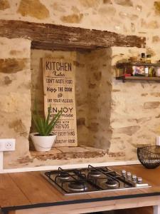 a kitchen with a stove top with a sign on the wall at Logement Cosy 2 à 4 Personnes Campagne proche Mer in Frossay