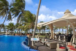 a resort pool with chairs and a gazebo at Radisson Blu Resort Galle in Galle