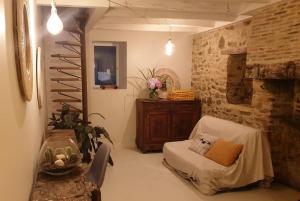 - un salon avec un lit et un mur en pierre dans l'établissement Logement Cosy 2 à 4 Personnes Campagne proche Mer, à Frossay