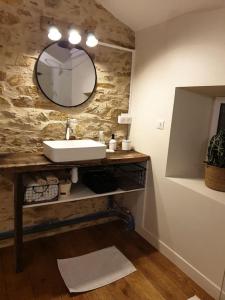 a bathroom with a sink and a mirror on the wall at Logement Cosy 2 à 4 Personnes Campagne proche Mer in Frossay