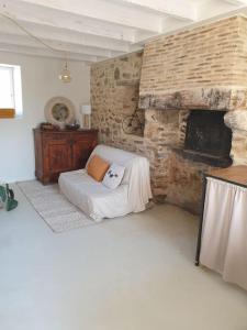 a room with a stone fireplace with a bed in it at Logement Cosy 2 à 4 Personnes Campagne proche Mer in Frossay
