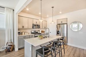 a kitchen with white cabinets and a large island with bar stools at Cozy Montana Retreat with Patio and Fire Pit! in Billings