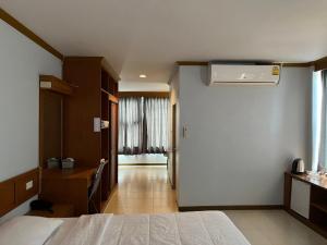 um quarto de hotel com uma cama e ar condicionado em Naraigrand Hotel (โรงแรมนารายณ์แกรนด์) em Chai Badan