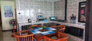 a kitchen with a table and some chairs and a counter at Tonmai Aquablue in Ko Lanta
