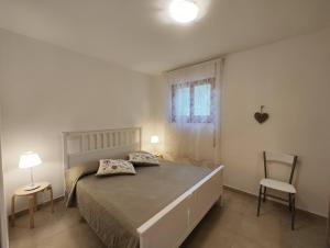 カステッラネータ・マリーナにあるCollins Apartmentsのベッドルーム1室(ベッド1台、椅子2脚、窓付)