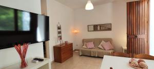 a living room with a couch and a flat screen tv at Collins Apartments in Castellaneta Marina 