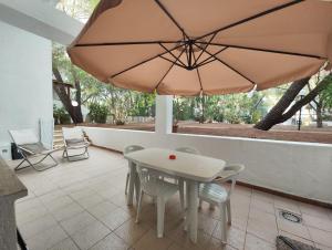 a table and chairs and an umbrella on a patio at Collins Apartments in Castellaneta Marina 