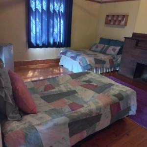 a room with two beds and a couch and windows at Alo guesthouse in Pietermaritzburg