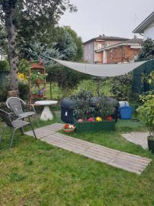 un jardín con mesa, hamaca y plantas en Bed & Breakfast Agli Aceri, en Verona