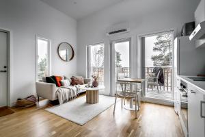 a white living room with a couch and a table at Relaxing Lake Oasis with Jacuzzi - Amazing view & Private Pier in Stockholm