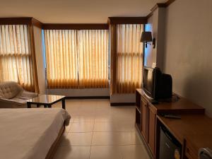 Habitación de hotel con cama y TV en Naraigrand Hotel (โรงแรมนารายณ์แกรนด์), en Chai Badan