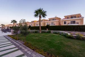a large house with a palm tree in a yard at Arena Beach Resort & Spa in Hurghada