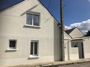 a white house with two windows on a street at Maisonnette cosy à Châtillon-Coligny in Châtillon-Coligny