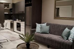 a living room with a couch and a table at Luxury 1 bedroom apartment in vibrant Menlyn Maine in Pretoria