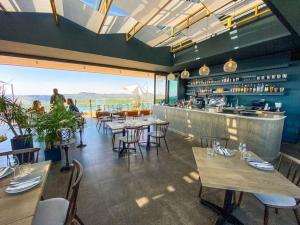 a restaurant with tables and chairs and a bar at Luxury 1 bedroom apartment in vibrant Menlyn Maine in Pretoria