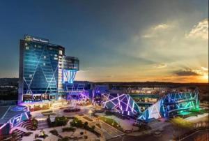 a large building with a lot of lights in front of it at Luxury 1 bedroom apartment in vibrant Menlyn Maine in Pretoria +11 photos