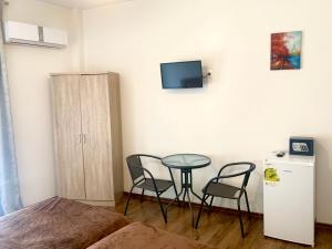 een slaapkamer met een kleine tafel en stoelen en een kleine koelkast bij Athens center rooms in Athene