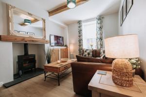 uma sala de estar com um sofá e uma lareira em Church View Cottage em Whalley