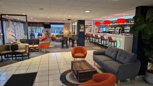 a lobby with a couch and chairs and a bar at Hostellerie Saint Vincent Beauvais Aeroport in Beauvais