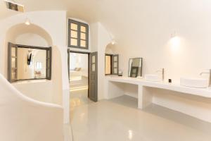 a white bathroom with two sinks and mirrors at Cilon Suites Santorini in Imerovigli