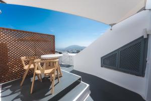 a balcony with two chairs and a table on a building at Cilon Suites Santorini in Imerovigli