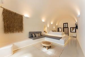 a living room with a couch and a bed at Cilon Suites Santorini in Imerovigli
