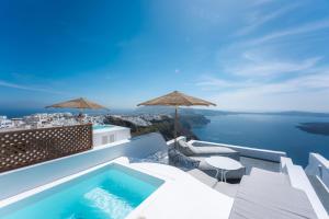 a villa with a swimming pool and a view of the ocean at Cilon Suites Santorini in Imerovigli