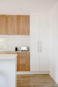 a kitchen with white cabinets and a counter at Nelson Central Town House in Nelson