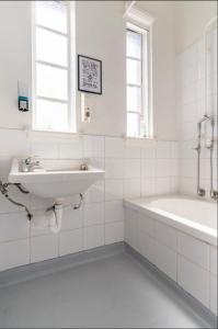 a white bathroom with a sink and a tub at Richmond Private Rooms - 151 Hoddle Homestay in Melbourne