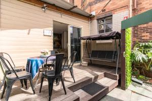 a patio with chairs and a table and an umbrella at Richmond Private Rooms - 151 Hoddle Homestay in Melbourne