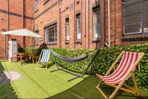 two lawn chairs and an umbrella on a patio at Richmond Private Rooms - 151 Hoddle Homestay in Melbourne