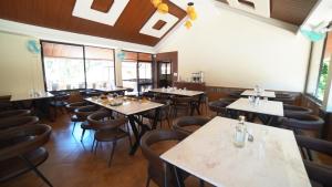 a restaurant with tables and chairs in a room at Aananda Wellness and Resorts in Dharmastala