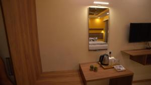Dharmastala的住宿－Aananda Wellness and Resorts，酒店客房设有一张桌子和一台电视机