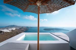 a view of the ocean from a villa with an umbrella at Cilon Suites Santorini in Imerovigli